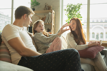 Image showing Family spending nice time together at home, looks happy and cheerful, eating pizza