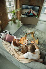 Image showing Family spending nice time together at home, looks happy and excited, eating pizza, watching basketball match