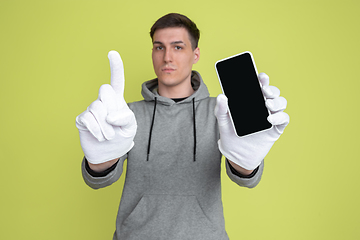 Image showing Caucasian man\'s portrait isolated on yellow studio background - freaky model