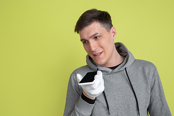 Image showing Caucasian man\'s portrait isolated on yellow studio background - freaky model