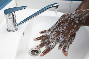 Image showing Man washing hands carefully in bathroom close up. Prevention of infection and pneumonia virus spreading