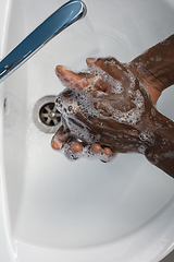 Image showing Man washing hands carefully in bathroom close up. Prevention of infection and pneumonia virus spreading