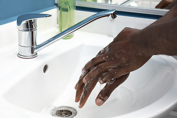 Image showing Man washing hands carefully in bathroom close up. Prevention of infection and pneumonia virus spreading