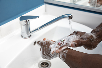 Image showing Man washing hands carefully in bathroom close up. Prevention of infection and pneumonia virus spreading