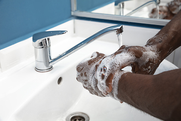 Image showing Man washing hands carefully in bathroom close up. Prevention of infection and pneumonia virus spreading