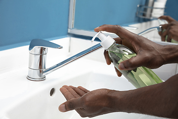 Image showing Man washing hands carefully in bathroom close up. Prevention of infection and pneumonia virus spreading