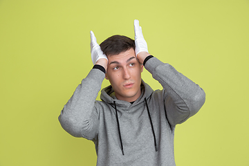 Image showing Caucasian man\'s portrait isolated on yellow studio background - freaky model