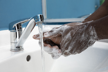 Image showing Man washing hands carefully in bathroom close up. Prevention of infection and pneumonia virus spreading