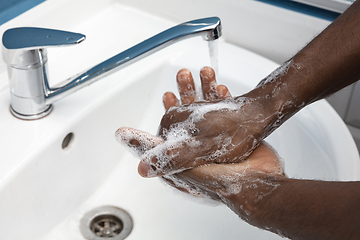 Image showing Man washing hands carefully in bathroom close up. Prevention of infection and pneumonia virus spreading