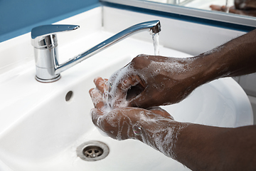 Image showing Man washing hands carefully in bathroom close up. Prevention of infection and pneumonia virus spreading