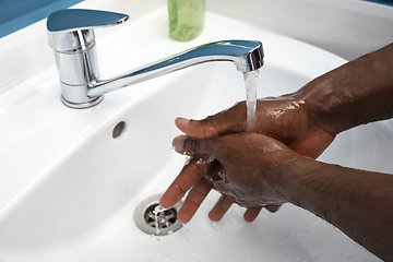 Image showing Man washing hands carefully in bathroom close up. Prevention of infection and pneumonia virus spreading