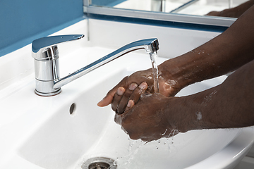 Image showing Man washing hands carefully in bathroom close up. Prevention of infection and pneumonia virus spreading