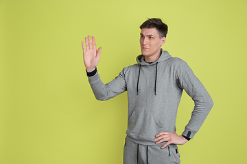 Image showing Caucasian man\'s portrait isolated on yellow studio background - freaky model