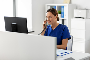 Image showing doctor with computer calling on phone at hospital