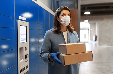 Image showing woman in mask with boxes at parcel machine