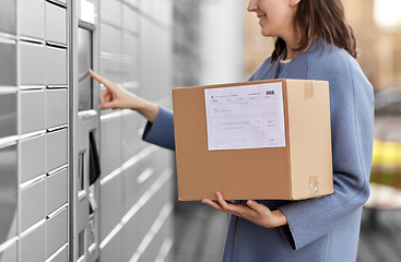 Image showing smiling woman with box at automated parcel machine