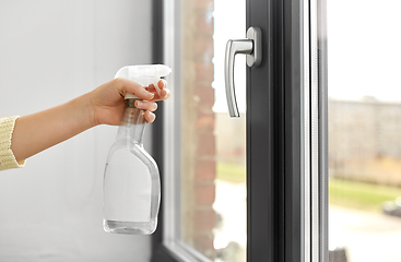 Image showing hands cleaning window handle with detergent