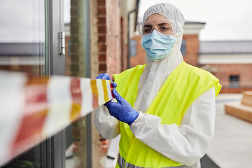 Image showing healthcare worker sealing door with caution tape