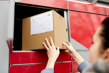 Image showing woman putting box to automated parcel machine