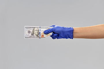 Image showing close up of hand in medical glove with money