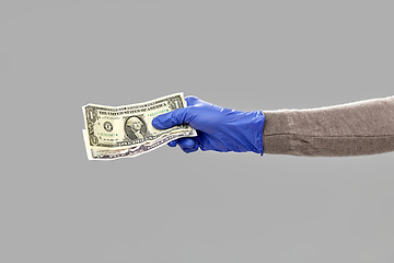 Image showing close up of hand in medical glove with money