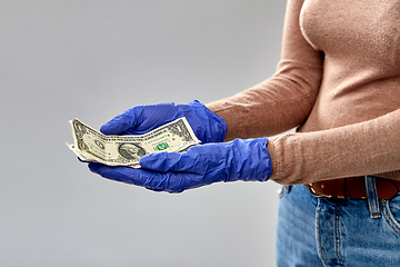 Image showing close up of hand in medical glove with money