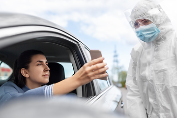 Image showing woman in car showing phohe to healthcare worker