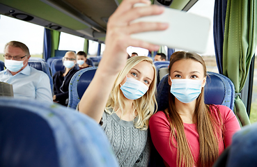 Image showing women in medical masks taking selfie in travel bus