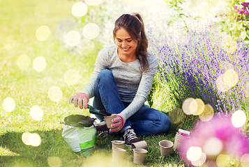 Image showing woman filling pots with soil at summer garden