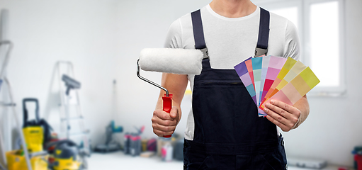 Image showing close up of painter with roller and color charts