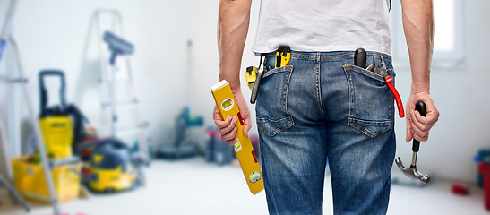 Image showing man with level and working tools in pockets
