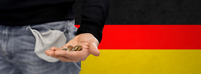 Image showing close up of man showing coins and empty pockets