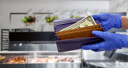Image showing close up of hands in gloves with dollar in wallet