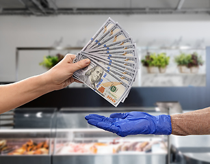 Image showing close up of hand in medical glove paying money