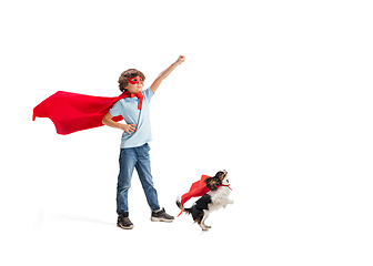 Image showing Child pretending to be a superhero with his super dog isolated on white studio background