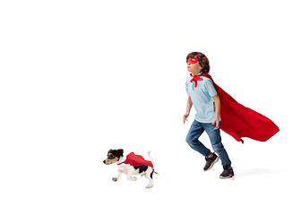 Image showing Child pretending to be a superhero with his super dog isolated on white studio background