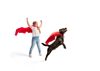 Image showing Child pretending to be a superhero with her super dog isolated on white studio background