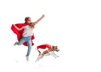 Image showing Child pretending to be a superhero with her super dog isolated on white studio background