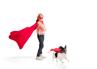 Image showing Child pretending to be a superhero with her super dog isolated on white studio background