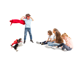 Image showing Child pretending to be a superhero with his super dog and friends sitting around