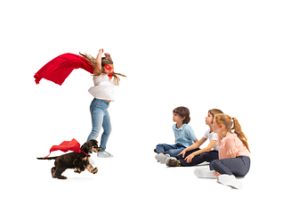 Image showing Child pretending to be a superhero with her super dog and friends sitting around