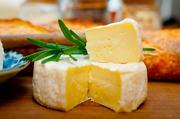 Image showing French cheese and fresh  baguette on a wood cutter