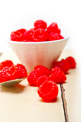 Image showing bunch of fresh raspberry on a bowl and white table