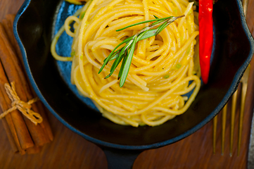 Image showing italian spaghetti pasta with zucchini sauce on iron skillet