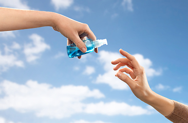 Image showing close up of hands giving each other gel sanitizer