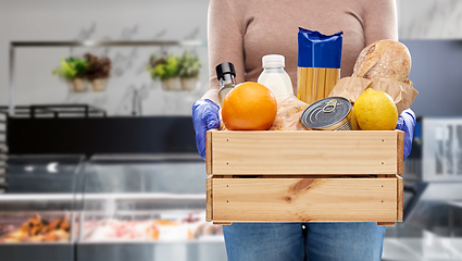 Image showing woman in gloves with food in wooden box