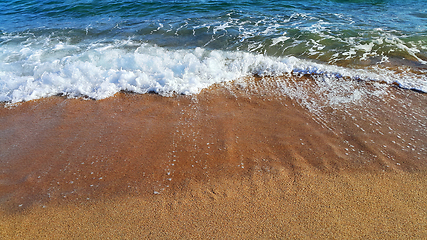 Image showing Sea wave with white foam on the coastal sand