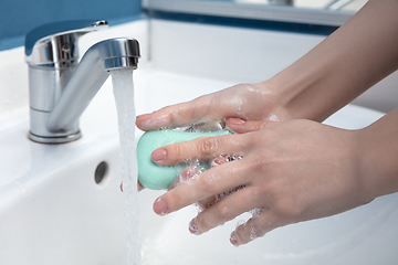 Image showing Woman washing hands carefully in bathroom close up. Prevention of infection and pneumonia virus spreading