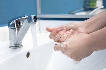 Image showing Woman washing hands carefully in bathroom close up. Prevention of infection and pneumonia virus spreading