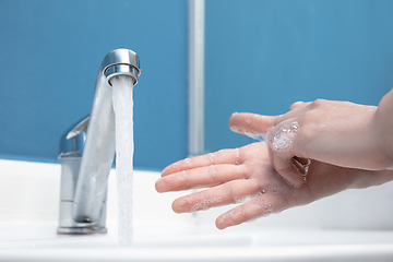 Image showing Woman washing hands carefully in bathroom close up. Prevention of infection and pneumonia virus spreading